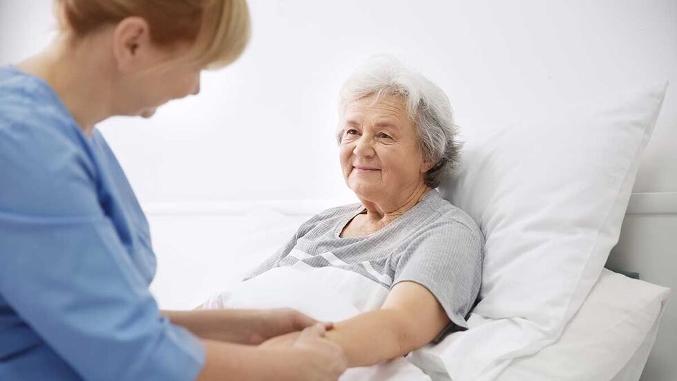 Seniorin wird von einer Pflegerin eines Pflegediensts umarmt
