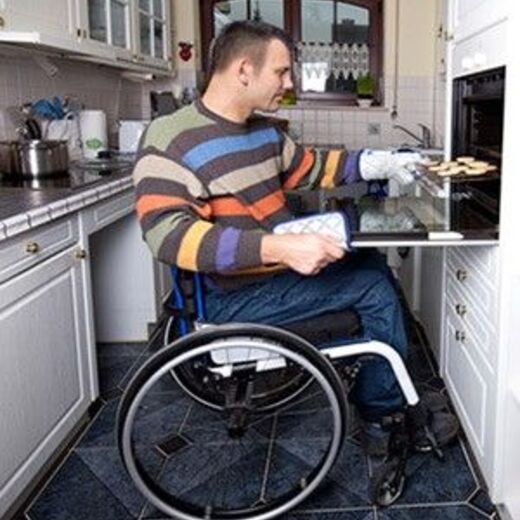 Wohnen mit Behinderung: Ein Rollstuhlfahrer in seiner behindertengerechten Küche